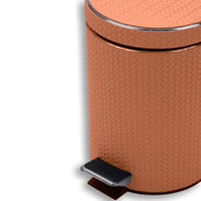 Close on the tan bin, chrome pedal plate at the foot and leather weave filling the body