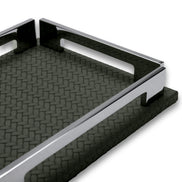 The khaki tray's long rail and side notch close up, woven-embossed leather running away in shadow