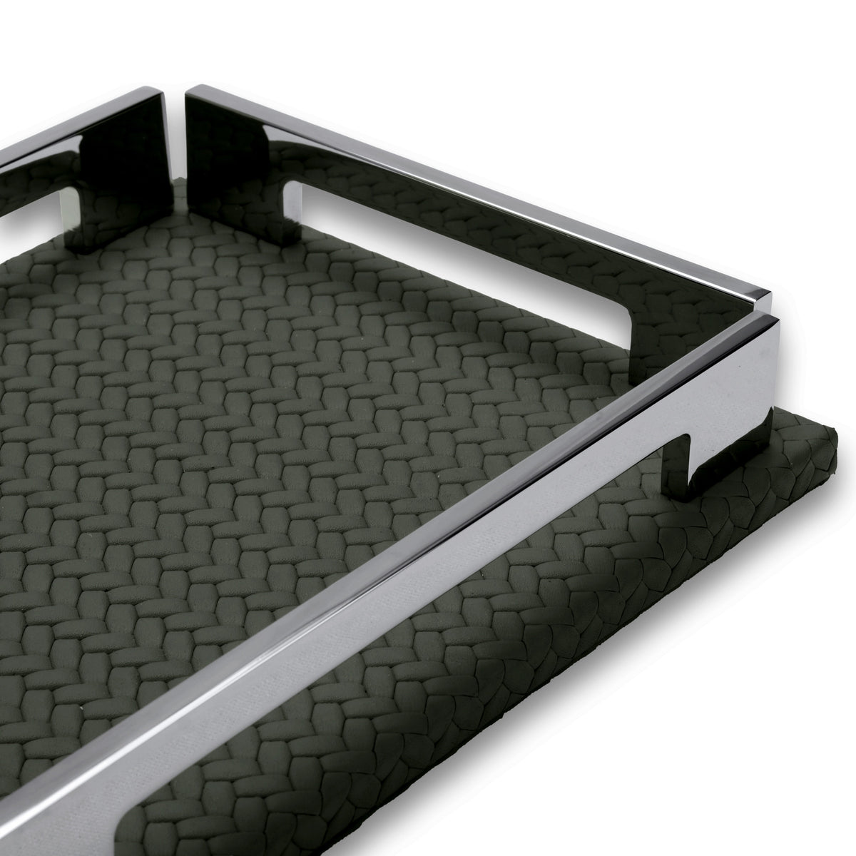 The khaki tray's long rail and side notch close up, woven-embossed leather running away in shadow