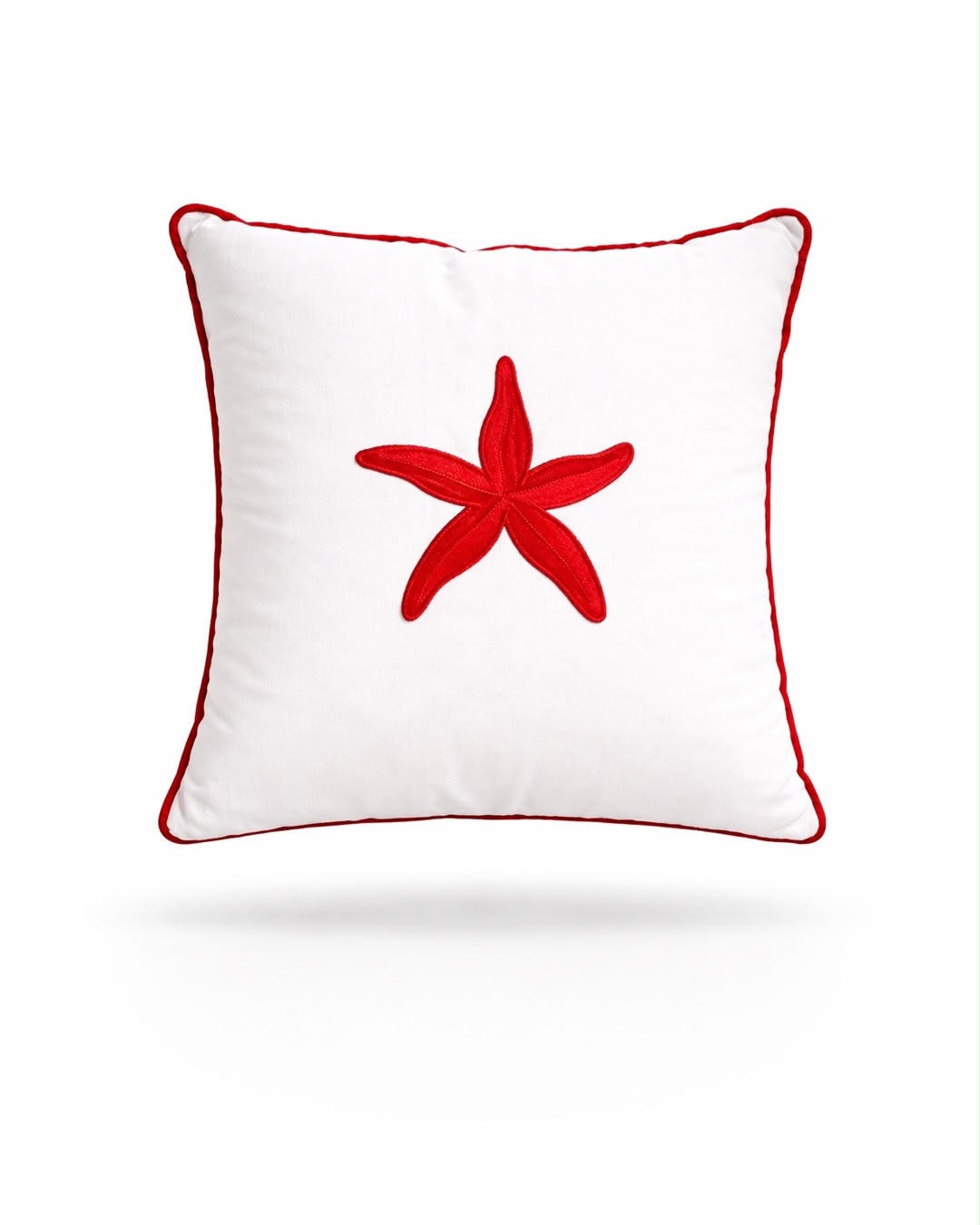 Red starfish embroidered on a white 45 x 45 cm outdoor cushion edged in red piping