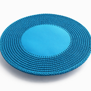 The blue round placemat angled, its leather centre flush inside a crocheted cord border