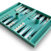 Turquoise woven leather backgammon board open, checkers laid out and two leather dice cups in play
