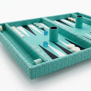 The 50 × 38 cm board angled, two leather-covered dice cups standing among the checkers on turquoise woven leather
