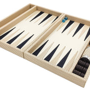 Cream woven leather backgammon set open flat, navy and cream points, dice cups and dark checkers in the side rail