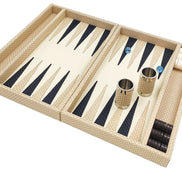 Cream woven leather backgammon board angled, two leather-covered dice cups standing on the playing field