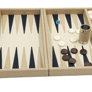 Cream leather backgammon set seen from the front, cream and dark checkers laid out beside a leather dice cup