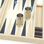 Close-up of cream basket-weave leather dice cups with polished metal rims beside navy woven points
