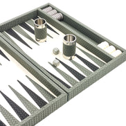Sage green leather dice cups with polished rims on the ivory playing field of the backgammon board