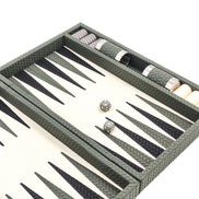 Sage green woven leather backgammon board angled, grey dice and checkers stacked in the side rail