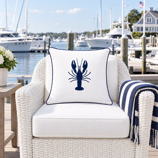 Nautical Embroidered Outdoor Cushion – White, navy lobster design — the terrace of a New England-style yacht club overlooking the marina
