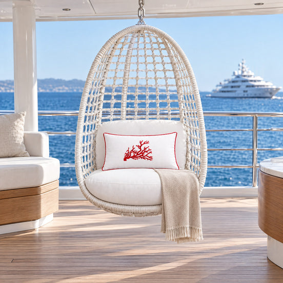 Coral Embroidered Rectangular Outdoor Cushion – White, red coral — a hanging egg chair of white woven rope on the upper deck