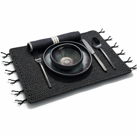 Black woven cord placemat crocheted by hand, coral trim along the edge