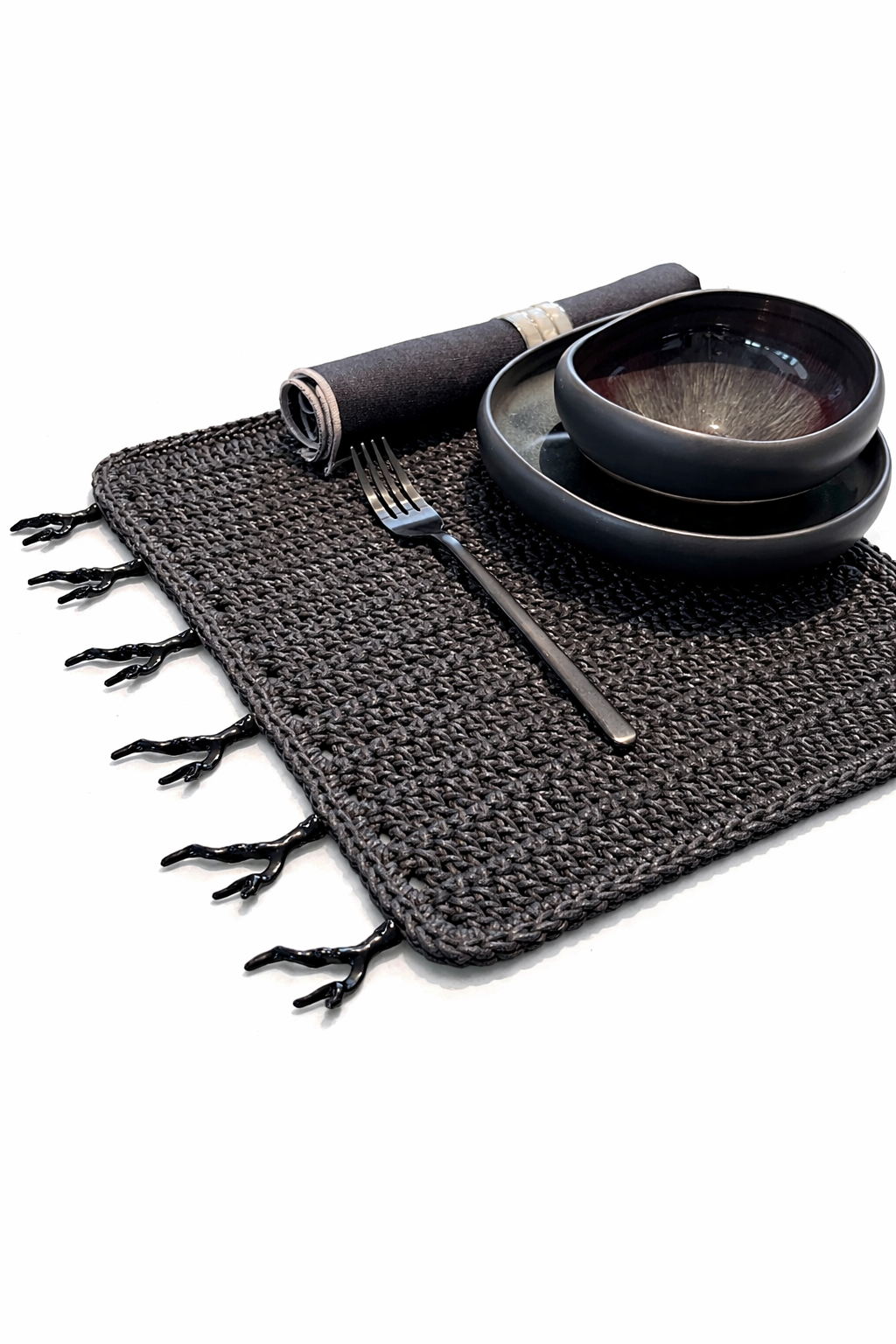 Black cord placemat with black coral trim on its edge