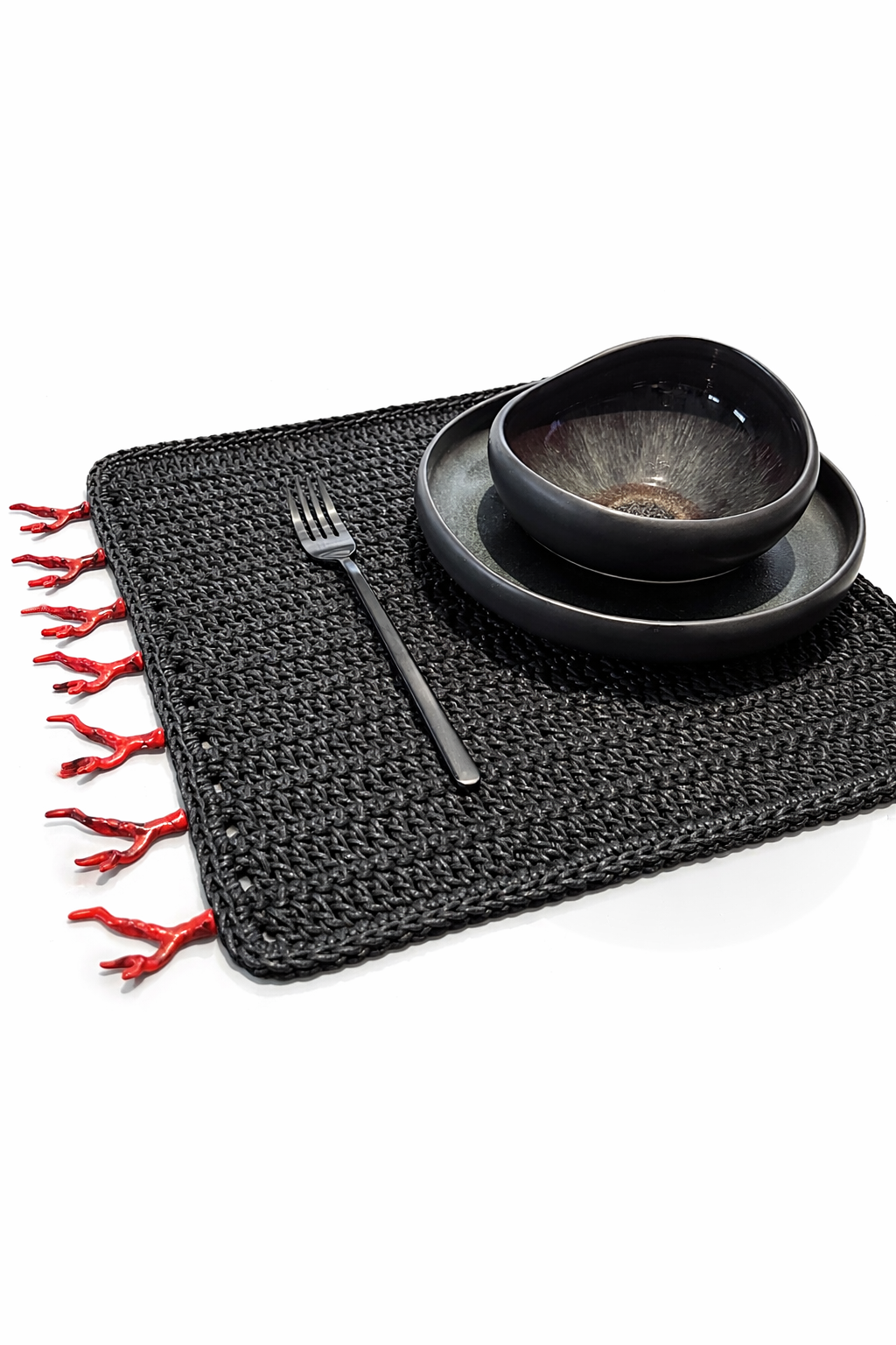 Black cord placemat with red coral trim along the edge