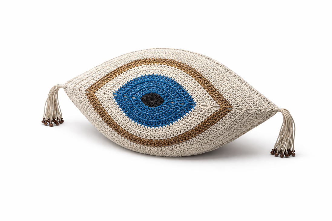 The cream and gold evil eye cushion, beaded tassels at the corners