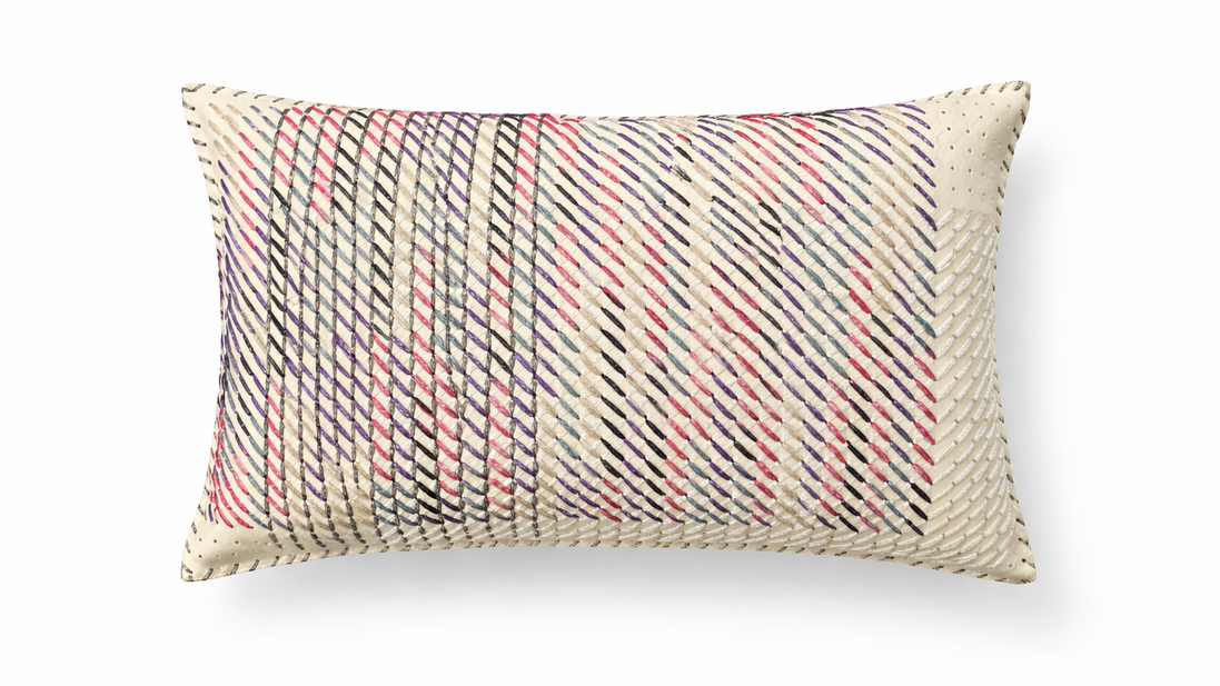 The ecru hand-laced cushion at an angle, diagonal rows of stitching