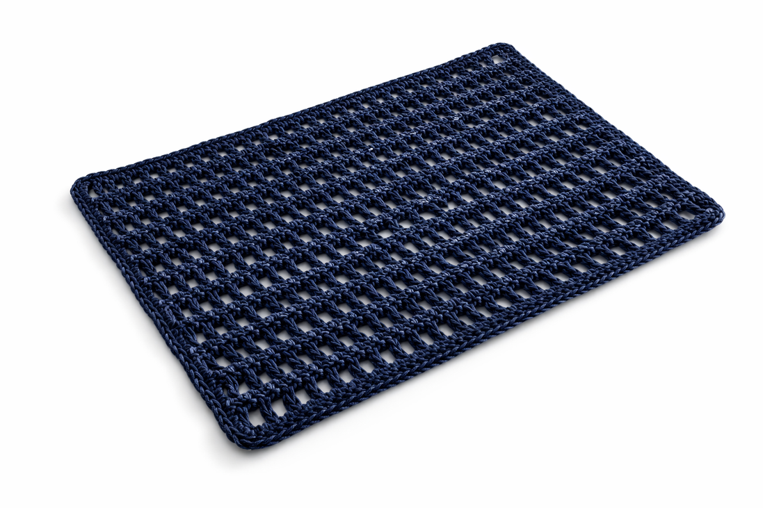 The navy leather cord placemat at an angle on a white ground