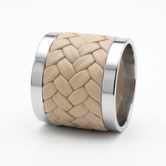 The beige napkin ring on its side, braid detail visible